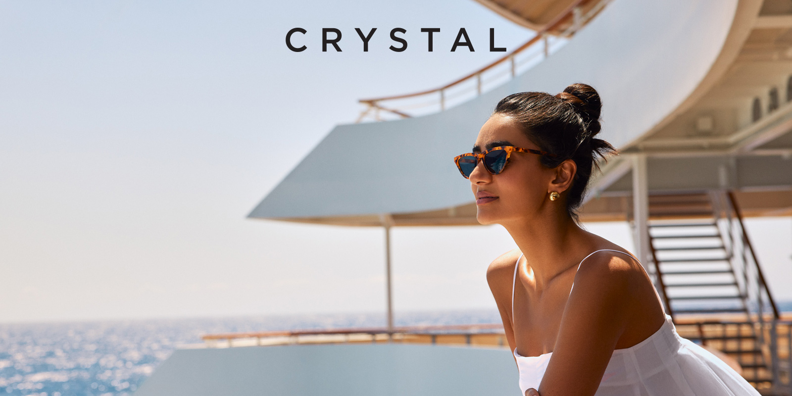 Woman standing in the sun along the rail of the Crystal Symphony